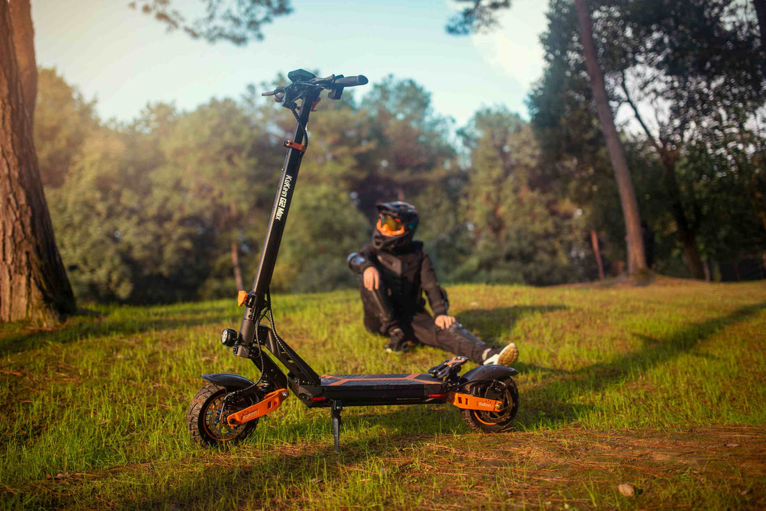 KuKirin G2 Max electric scooter with rider in protective gear in an outdoor park, showcasing the model's off-road design for commuters (featured in KuKirin G2 vs G2 Max comparison)