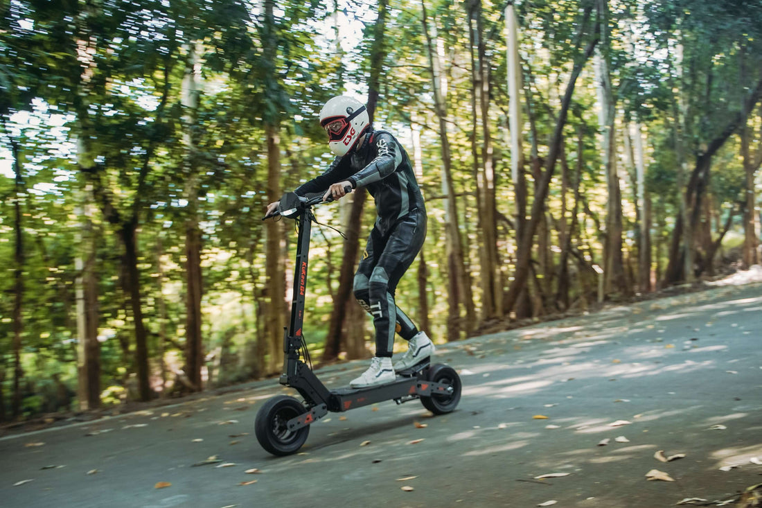 Rider in protective gear riding KuKirin G4 2000W electric scooter on forest road, showcasing off-road performance of 60V 20Ah adult e-scooter