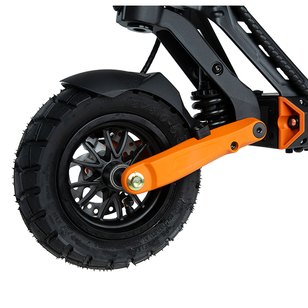 Close-up of the front wheel and orange suspension on the DGT-certified KuKirin G2 Pro VMP electric scooter, showing the robust tire tread and striking color contrast