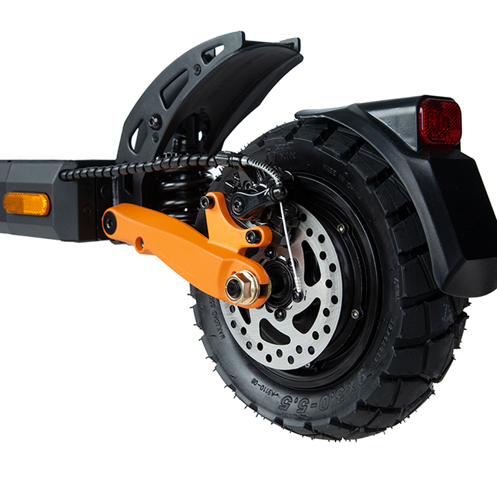 Close-up of the rear wheel on the KuKirin G2 Pro (VMP) electric scooter, showcasing the robust 9-inch vacuum tire, orange brake caliper, and distinctive rim design.